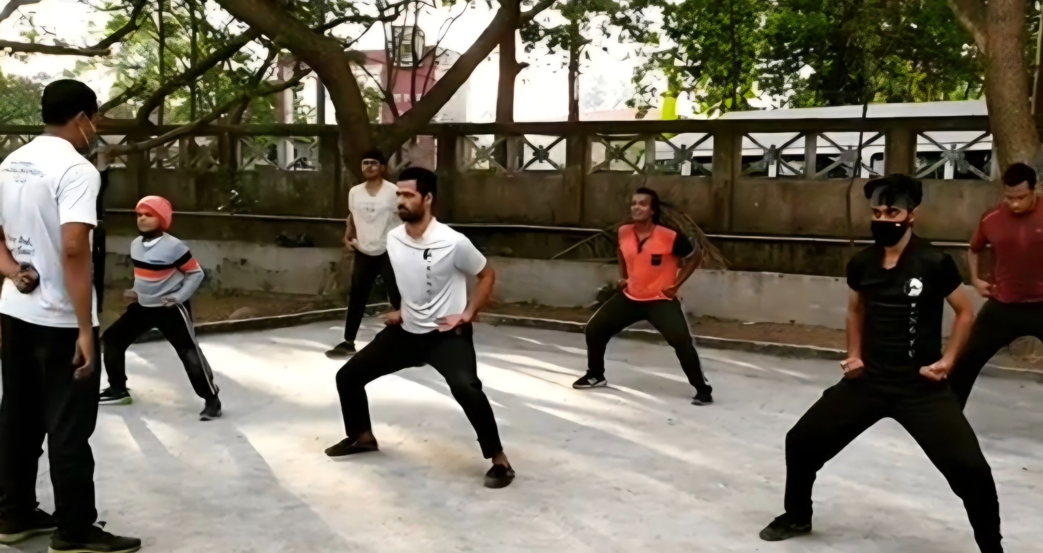 Kung fu students holding their stance during an outdoor group class